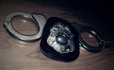 A police badge and handcuffs on a table