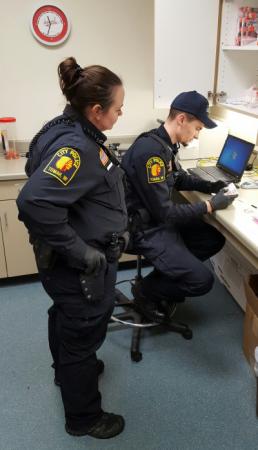 Two officers looking at material on a desk.