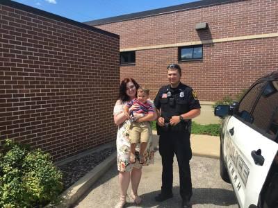 A police officer standing with a woman holding a child